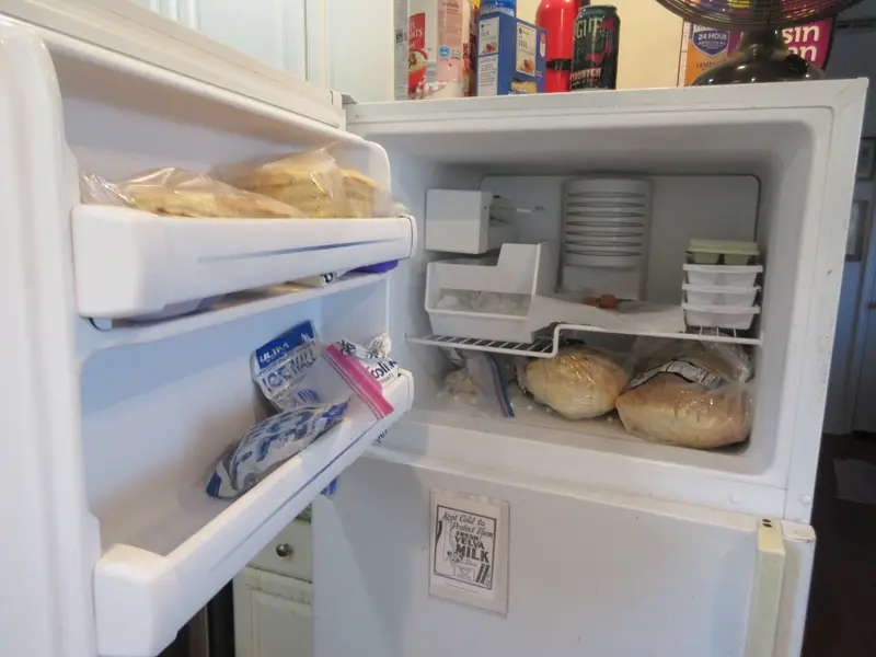 Open home freezer compartment stocked with frozen food, the kind of unit we handle in freezer repair